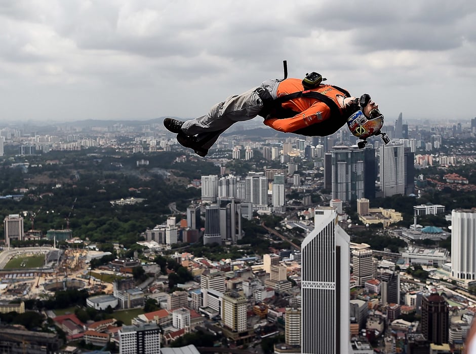 base jumpers leap from the 300 metre high skydeck of malaysia 039 s landmark kuala lumpur tower against the backdrop of the city 039 s skyline during the annual international kl tower base jump event photo afp