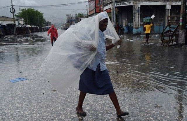 a woman protects herself from the rain with plastic after hurricane matthew in port au prince on oct 4 2016 photo afp a woman protects herself from the rain with plastic after hurricane matthew in port au prince on oct 4 2016 photo afp