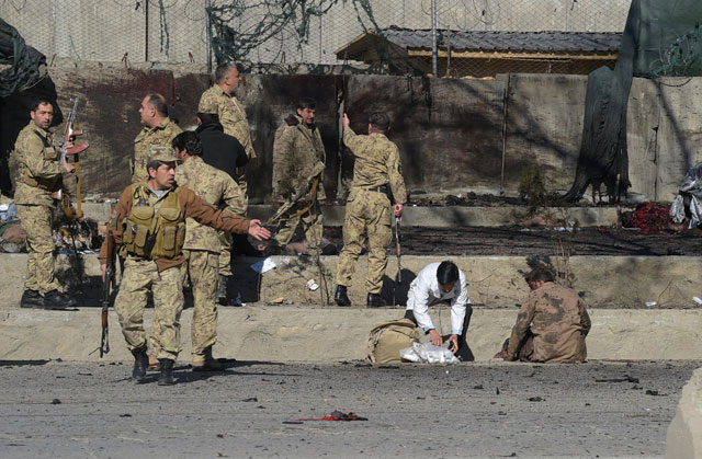 afghan security personnel gather as victims are treated at the site of a suicide car bomb next to a police base in kabul on february 1 2016 photo afp