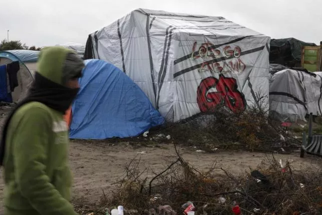 a migrants walks past a tent with a graffiti reading quot let 039 s go england quot in the quot new jungle quot makeshift camp as unseasonably cool temperatures arrive in calais northern france photo reuters a migrants walks past a tent with a graffiti reading quot let 039 s go england quot in the quot new jungle quot makeshift camp as unseasonably cool temperatures arrive in calais northern france photo reuters