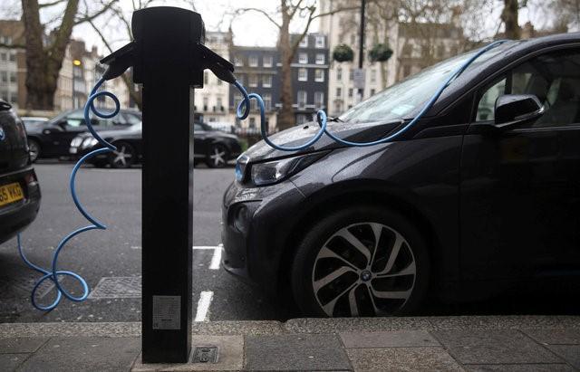 electric cars are plugged into a charging point in london britain photo reuters