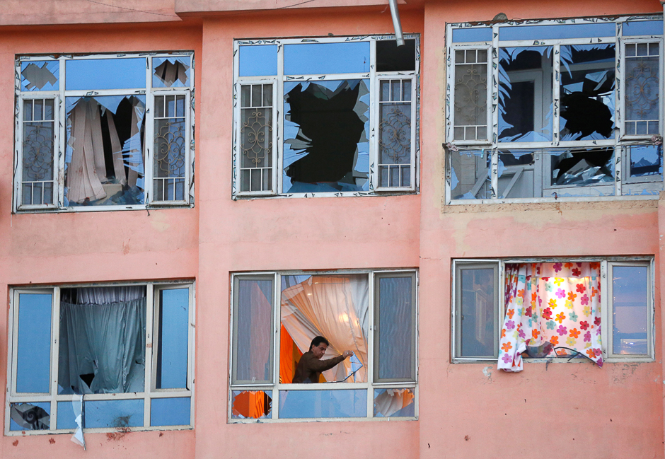 an afghan man removes glasses from his apartment at the site of a suicide attack in kabul afghanistan photo reuters