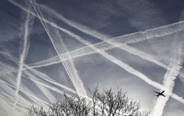 a passenger plane flies through aircraft contrails in the skies near heathrow airport in london britain photo reuters