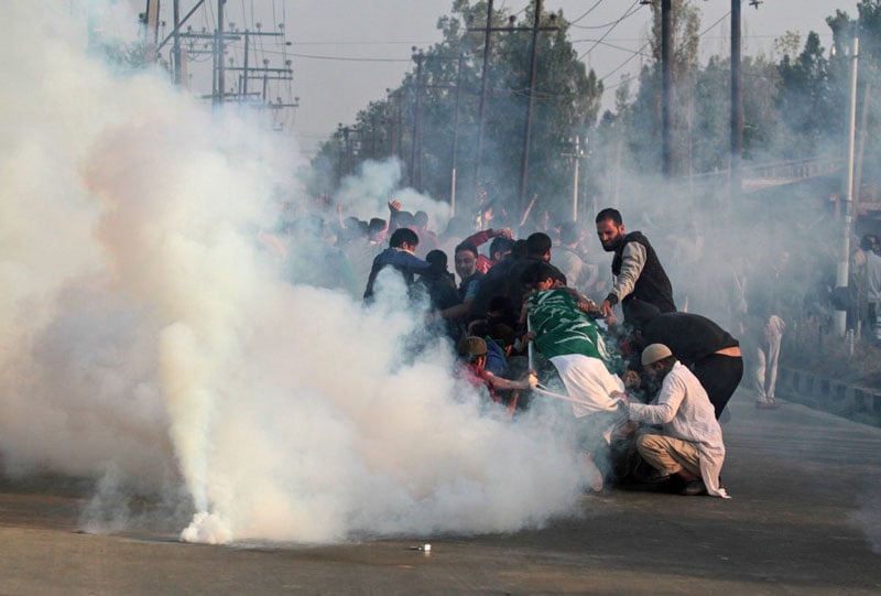 kashmiri mourners hold the body of junaid ahmad 12 as they are fired on with tear gas by indian police during his funeral procession in downtown srinagar on october 8 2016 photo afp