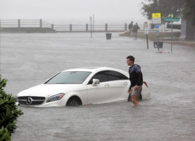 a resident walks through flood waters next to a partially submerged car on east battery street at the southern most tip of the city as hurricane matthew hits charleston south carolina october 8 2016 photo reuters