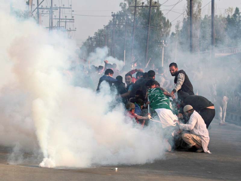 mourners hold the body of junaid ahmad 12 as indian police fire tear gas shells at them photo afp