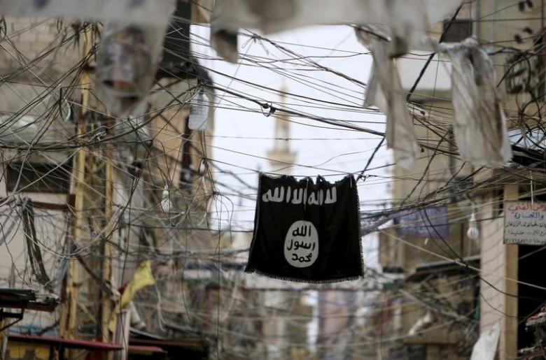 an islamic state flag hangs amid electric wires over a street photo reuters