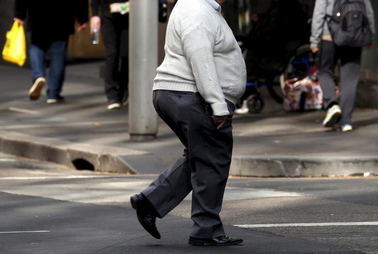 a man crosses a main road as pedestrians carrying food walk along the footpath in central sydney australia photo reuters