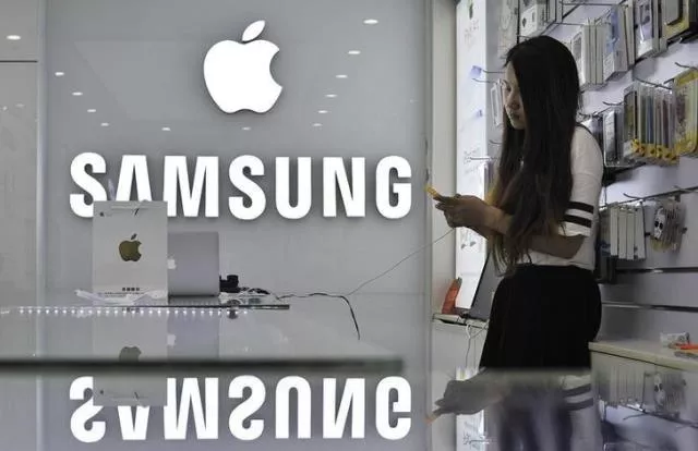a sales assistant uses her mobile phone next to the company logos of apple and samsung at a store in hefei anhui province september 10 2014 photo reuters a sales assistant uses her mobile phone next to the company logos of apple and samsung at a store in hefei anhui province september 10 2014 photo reuters