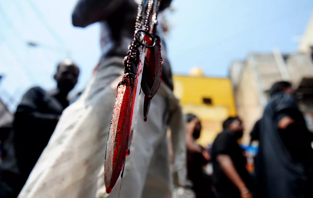 shia muslim man holds blood stained blades as he self flagellates during the mourning procession on the tenth day of muharram which marks the day of ashura photo afp shia muslim man holds blood stained blades as he self flagellates during the mourning procession on the tenth day of muharram which marks the day of ashura photo afp