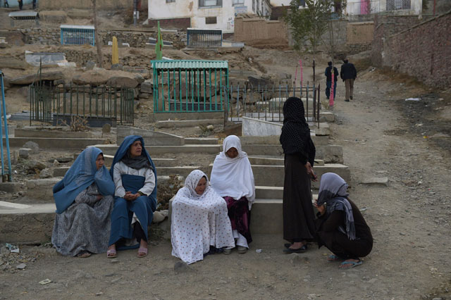 afghan women sit next to a grave yard near the karte sakhi shrine after an attack by gunmen inside the karte sakhi shrine in kabul on october 12 2016 photo afp file