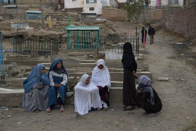 afghan women sit next to a grave yard near the karte sakhi shrine after an attack by gunmen inside the karte sakhi shrine in kabul on october 12 2016 photo afp