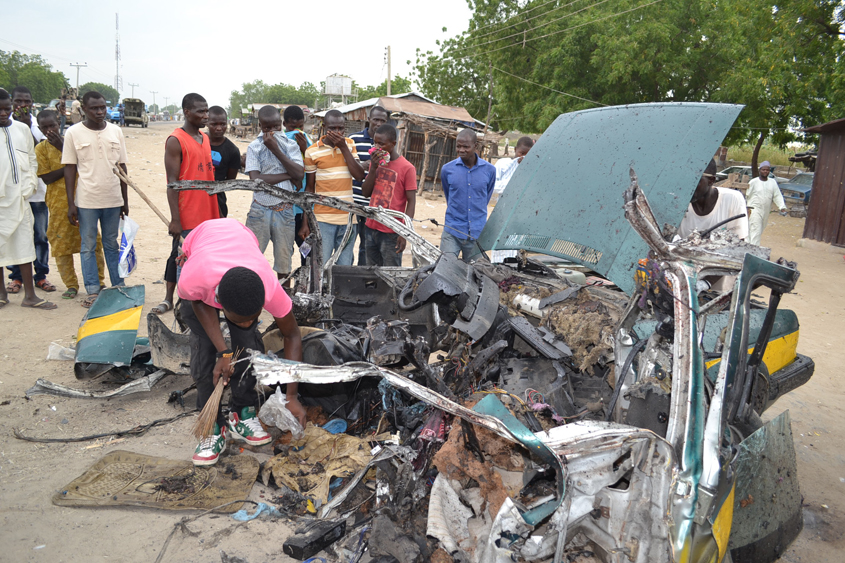 people gather at the site of a car blast in maiduguri northeast borno state in nigeria on october 12 2016 where 8 people were killed and dozen injured photo afp