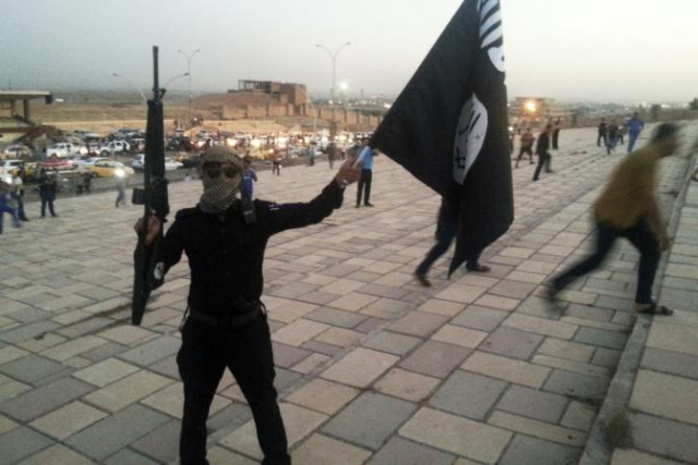a fighter of the islamic state of iraq and the levant isil holds an isil flag and a weapon on a street in the city of mosul iraq june 23 2014 photo reuters a fighter of the islamic state of iraq and the levant isil holds an isil flag and a weapon on a street in the city of mosul iraq june 23 2014 photo reuters