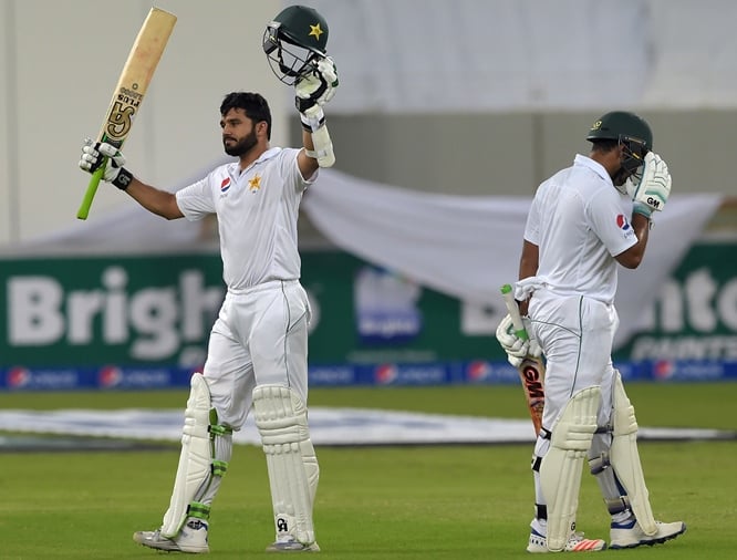 pakistani batsman azhar ali l raises his bat as he celebrates after scoring a century 100 runs next to his teammate sami aslam on the opening day of the first day night test between pakistan and the west indies at the dubai international cricket stadium in the gulf emirate on october 13 2016 openers azhar ali and sami aslam gave pakistan a solid start against west indies on the opening day of the day night test photo afp