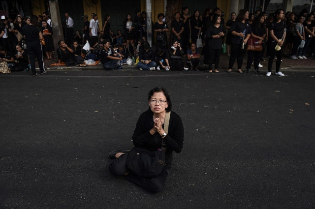 a woman prays to the late thai king bhumibol adulyadej outside of the grand palace in bangkok photo afp a woman prays to the late thai king bhumibol adulyadej outside of the grand palace in bangkok photo afp