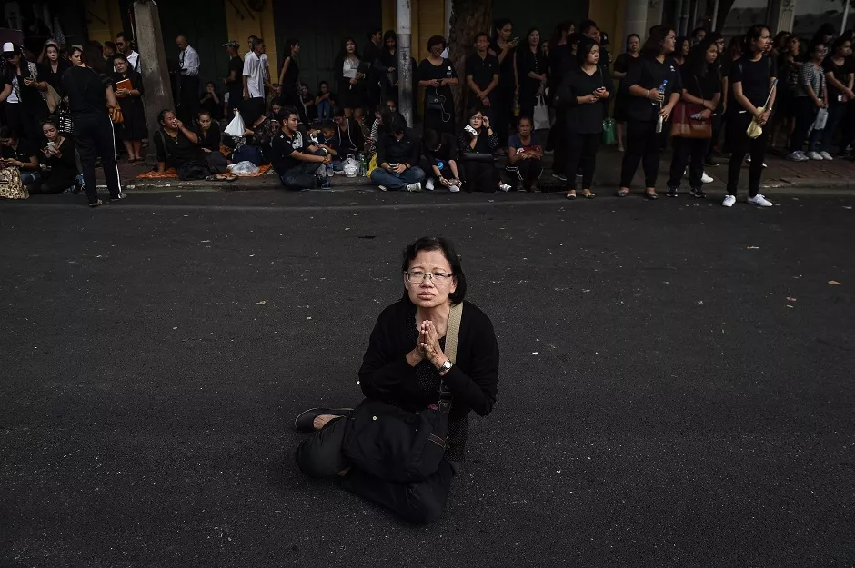 a woman prays to the late thai king bhumibol adulyadej outside of the grand palace in bangkok photo afp a woman prays to the late thai king bhumibol adulyadej outside of the grand palace in bangkok photo afp