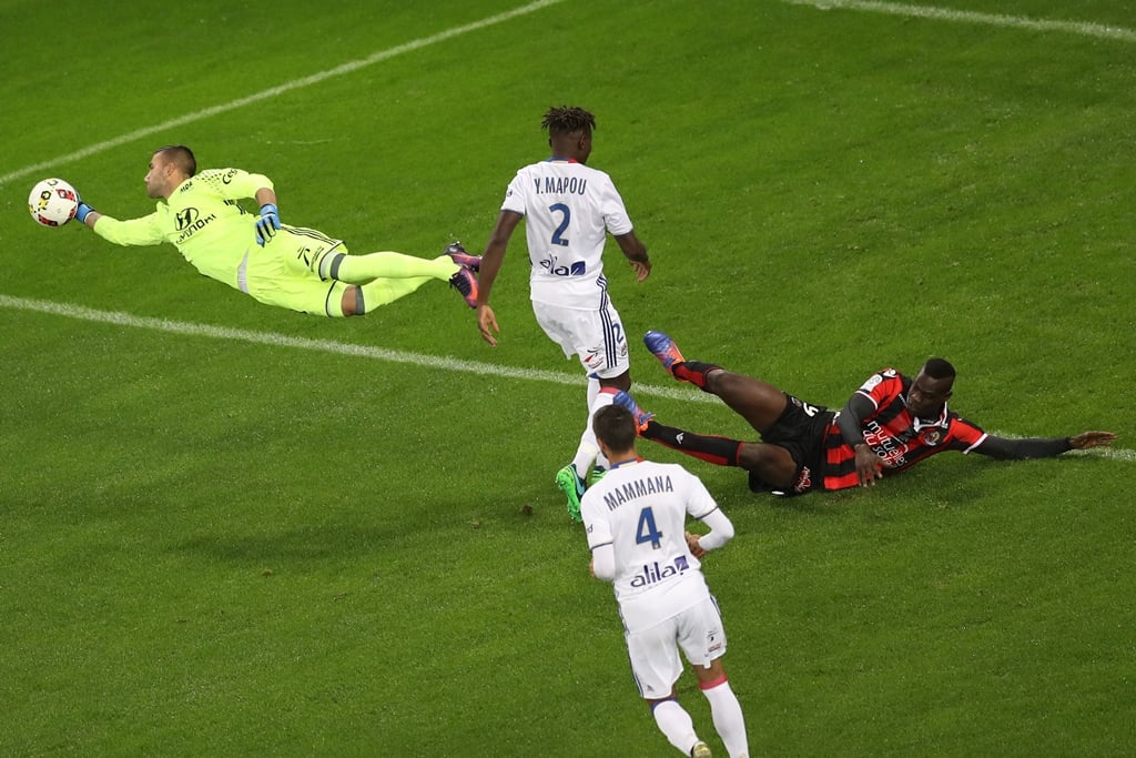 mario balotelli r falls as anthony lopes l deflects a shot photo afp