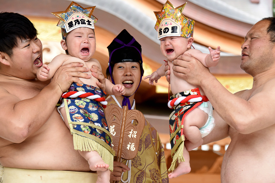 sumo wresters hold up crying babies in front of a referee c clad in a traditional costume during a baby cry sumo event at the kamegaike hachiman shrine in sagamihara kanagawa prefecture photo afp