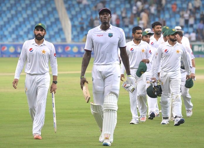 pakistani captain misbah ul haq l holds the wicket next to west indies captain jason holder c as they back to pavilion after pakistan winning the test match on the final day of the first day night test between pakistan and the west indies at the dubai international cricket stadium in the gulf emirate on october 17 2016 photo afp