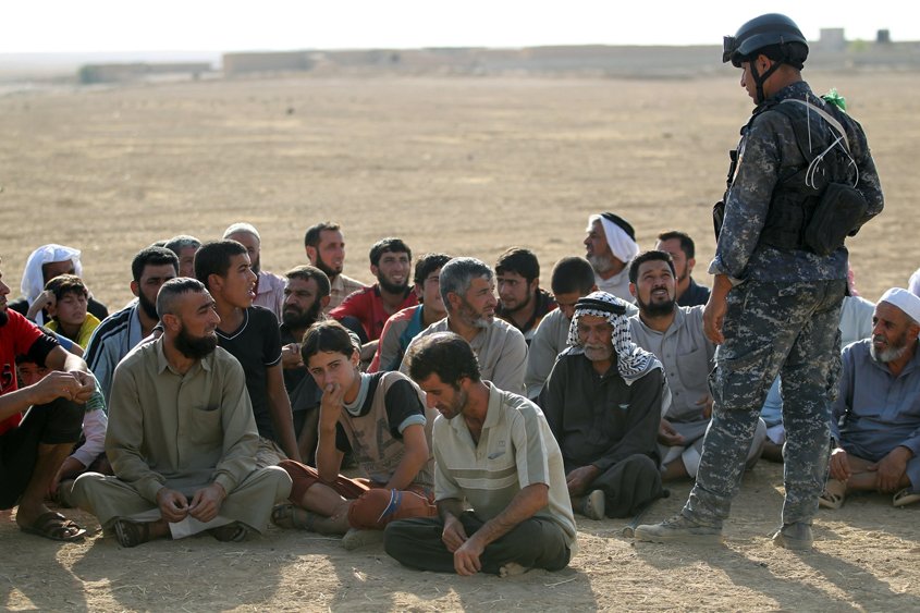 displaced iraqis from the bajwaniyah village about 30 kms south of mosul who fled fighting in the mosul area gather as iraqi security forces enter the village on october 18 2016 after they liberated it from islamic state is group extremists photo afp