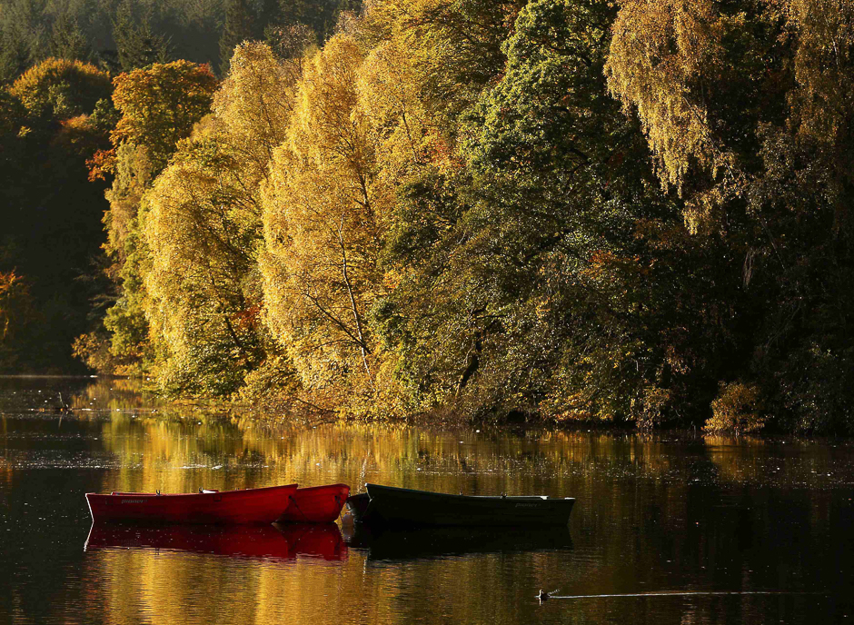 moored boats are seen on loch faskally as autumn leaves are reflected in the water in pitlochry scotland photo reuters