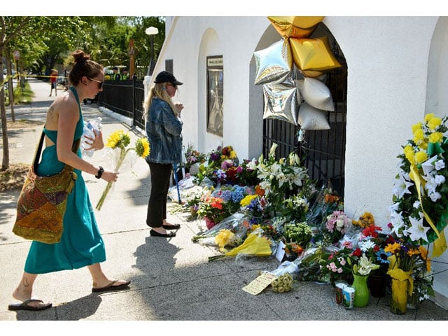 mourners gather at a makeshift memorial outside the emanuel ame church in charleston south carolina on june 18 2015 after a mass shooting the night before photo afp