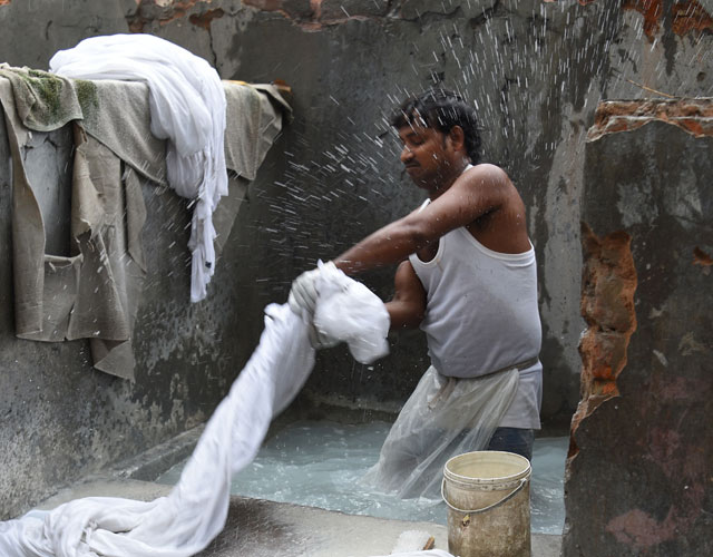 in this photograph laundry worker dharam nath 22 stands in a stone bath as he beats items of clothing photo afp