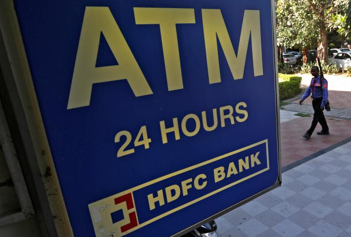 a private security guard moves past a signboard of an icici automated teller machine atm in new delhi india photo reuters