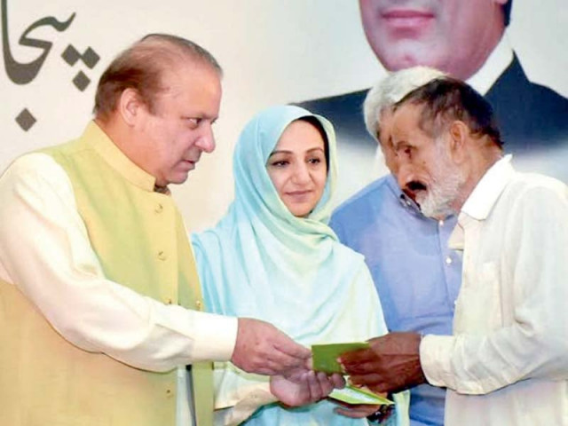 pm gives a health card to a man at a ceremony photo inp pm gives a health card to a man at a ceremony photo inp