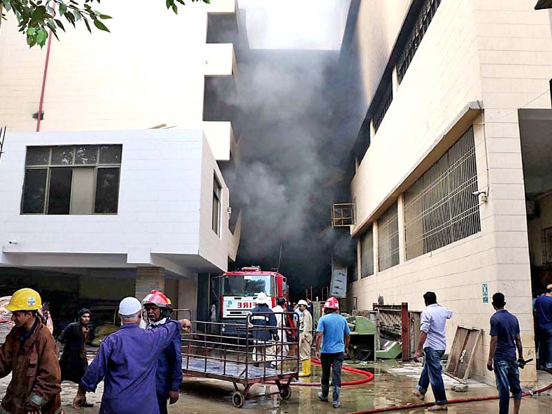 firefighters seen busy putting out the fire that erupted on the ground floor of the textile mill photo online