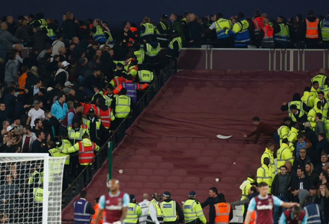 supporters of both sides confront each other and a broken seat is seen on the covered seats during the efl english football league cup fourth round match between west ham united and chelsea at the london stadium in east london on october 26 2016 photo afp