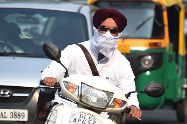 an indian biker wearing face protection against air pollution rides on the road in heavy smog in new delhi on october 28 2016