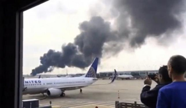 smoke rises after an american airlines jet background blew a tire sparking a fire and prompting the pilot to abort takeoff before passengers were evacuated from the plane via emergency chute at o 039 hare international airport in chicago illinois us in this still image taken from video october 28 2016 photo reuters