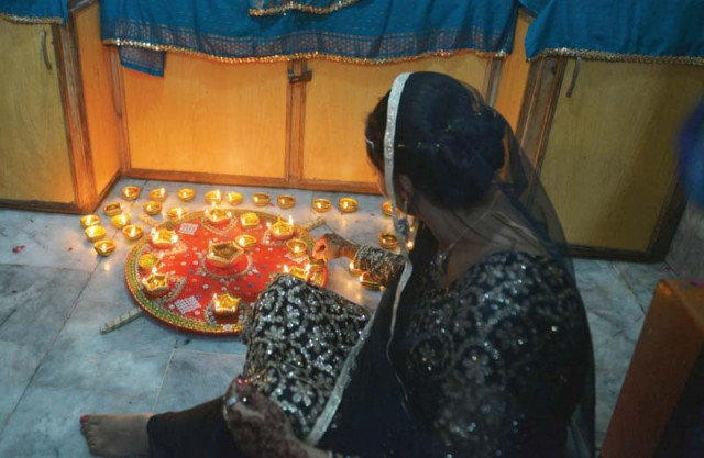 a woman lights clay lamps to celebrate diwali photos afp a woman lights clay lamps to celebrate diwali photos afp