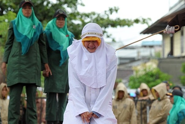 earlier today the 20 year old woman is led out on to the stage to receive her caning punishment photo afp