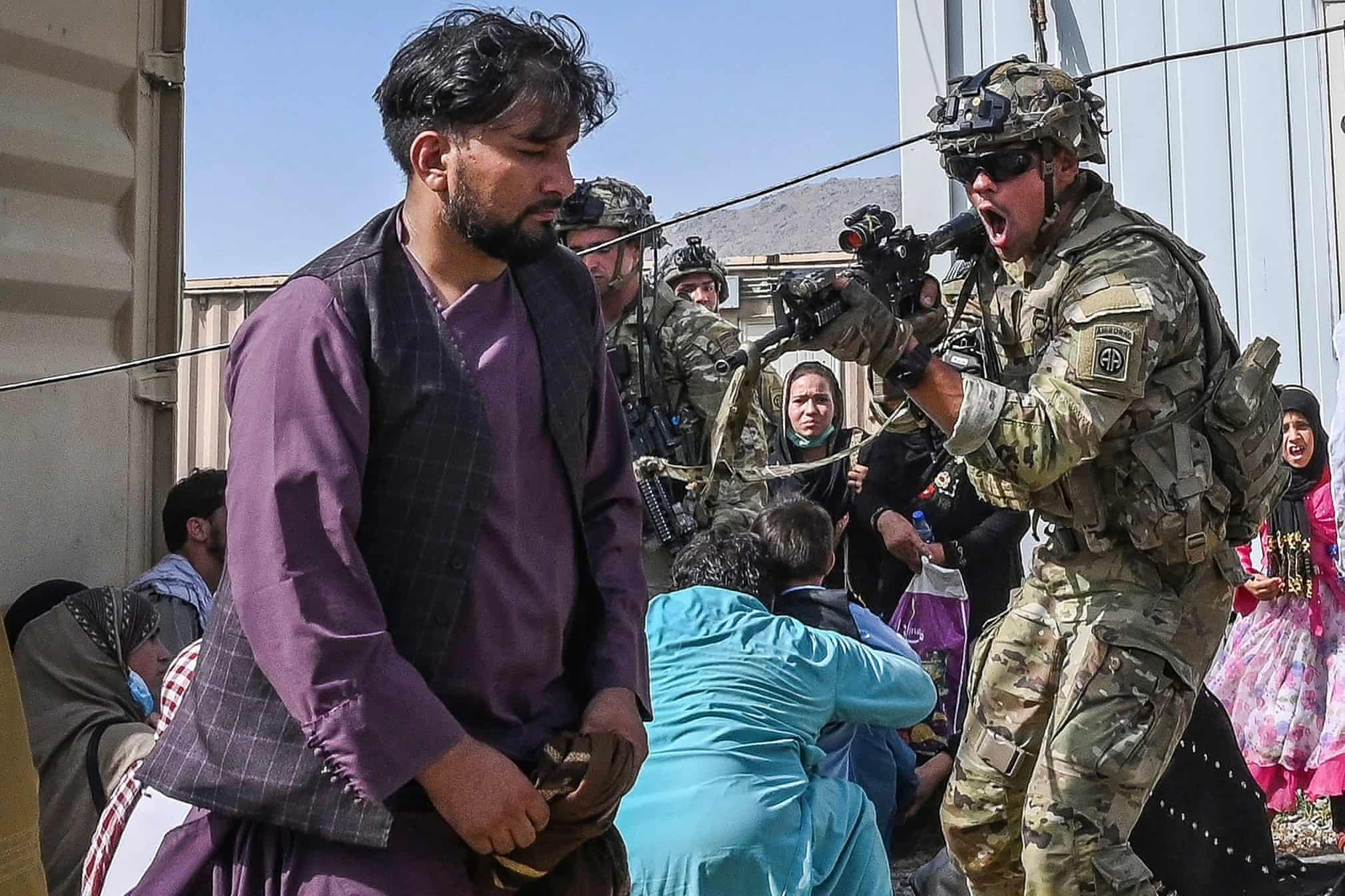 A US soldier points his gun towards an Afghan passenger at the airport. PHOTO: AFP