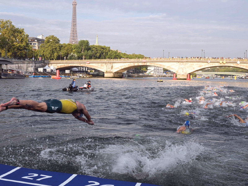 triathlon athlete dives in the seine river in this file photo with the eiffel tower in the background a number of pre olympics swimming events had to be cancelled here due to excessive pollution in the river which jeopardises the opening ceremony of the paris olympics 2024 photo afp