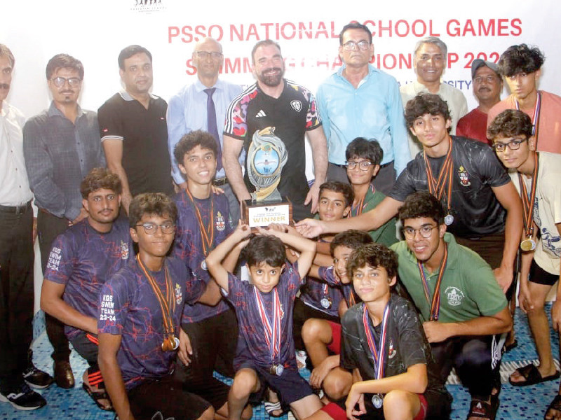 karachi grammar school team the winners of psso games boys swimming event pose with the trophy and guests of honour photo app