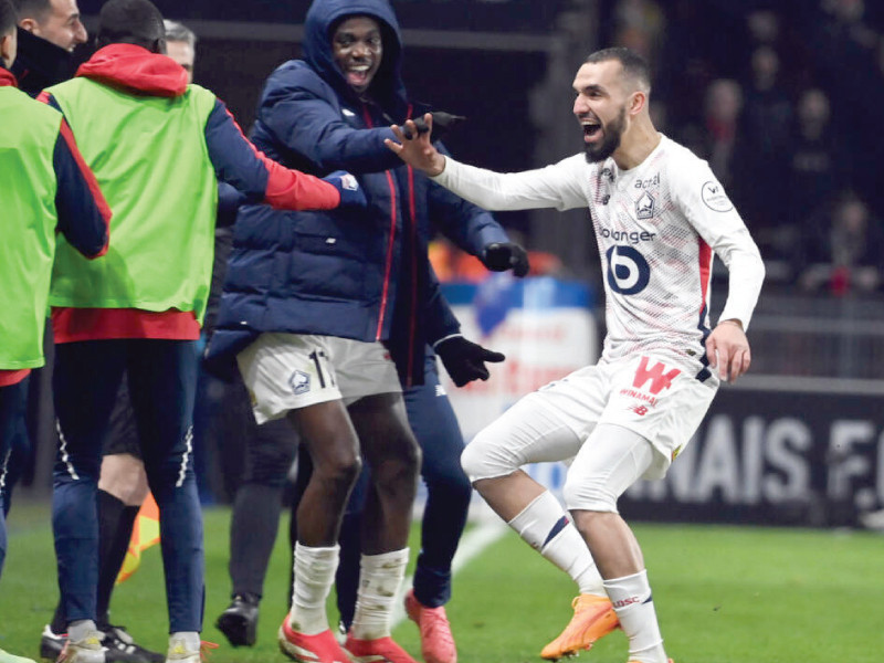 nabil bentaleb runs to the sideline to celebrate his comeback goal with lille substitutes and coaches photo afp