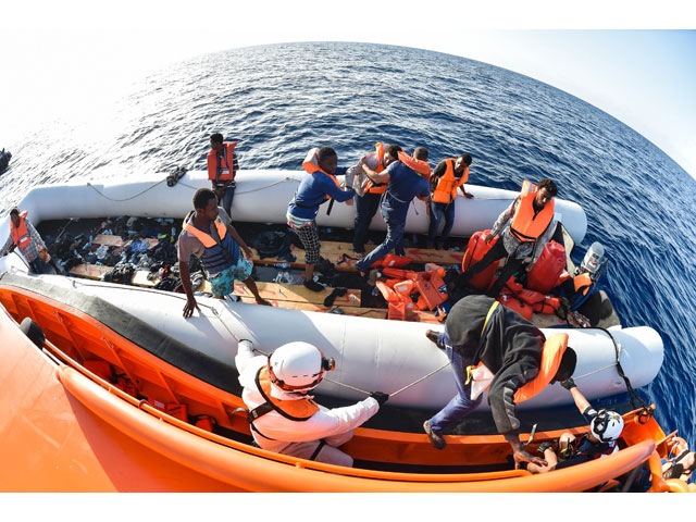 men evacuate a rubber boat with the help of the crew of the topaz responder ship run by maltese ngo moas and the italian red cross during a rescue operation of migrants and refugees on november 3 2016 off the libyan coast in the mediterranean sea photo afp