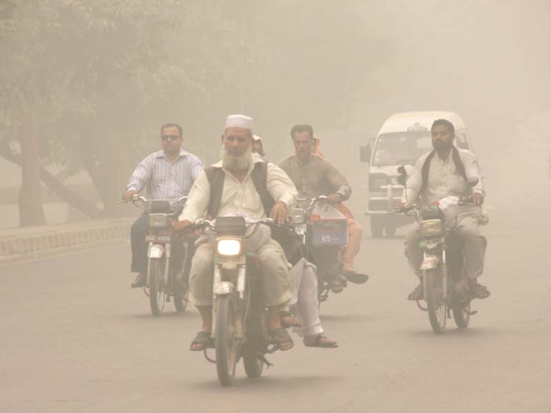 Motorcyclists drive through a thick blanket of smog in Lahore. PHOTO: ABID NAWAZ/EXPRESS