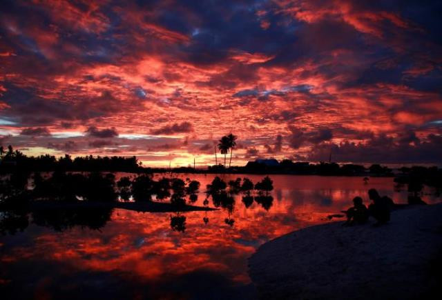 villagers watch the sunset over a small lagoon near the village of tangintebu on south tarawa in the central pacific island nation of kiribati may 25 2013 photo reuters villagers watch the sunset over a small lagoon near the village of tangintebu on south tarawa in the central pacific island nation of kiribati may 25 2013 photo reuters