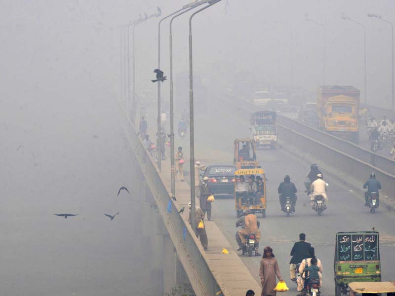 commuters wear masks as thick smog envelops lahore photo afp