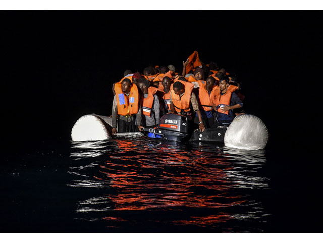 migrants and refugees wait for further assistance during a rescue operation by the topaz responder ship run by the maltese ngo moas and the italian red cross early morning on november 5 2016 off the coast of libya photo afp