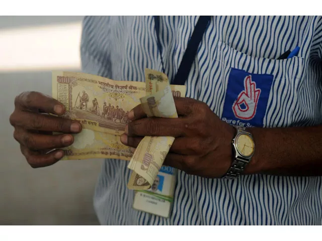 an indian worker holds a stack of 500 indian rupee notes on the forecourt of a fuel station in chennai on november 9 2016 photo afp an indian worker holds a stack of 500 indian rupee notes on the forecourt of a fuel station in chennai on november 9 2016 photo afp