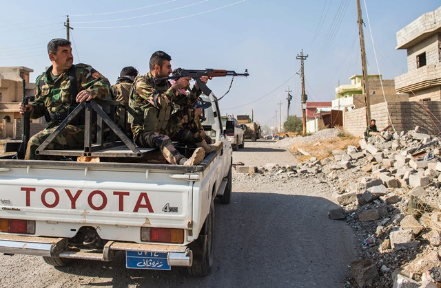 a peshmerga soldier returns fire as his convoy drives through an area exposed to a sniper on november 8 2016 as the iraqi kurdish forces pushed deeper into the town of bashiqa during street battles against islamic state is group jihadists photo afp a peshmerga soldier returns fire as his convoy drives through an area exposed to a sniper on november 8 2016 as the iraqi kurdish forces pushed deeper into the town of bashiqa during street battles against islamic state is group jihadists photo afp