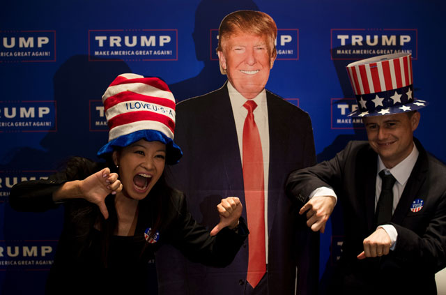 a couple poses for a picture next to a cardboard cut outs of us presidential candidat donald trump during an election event organised by the us consulate in shanghai on november 9 2016 photo afp