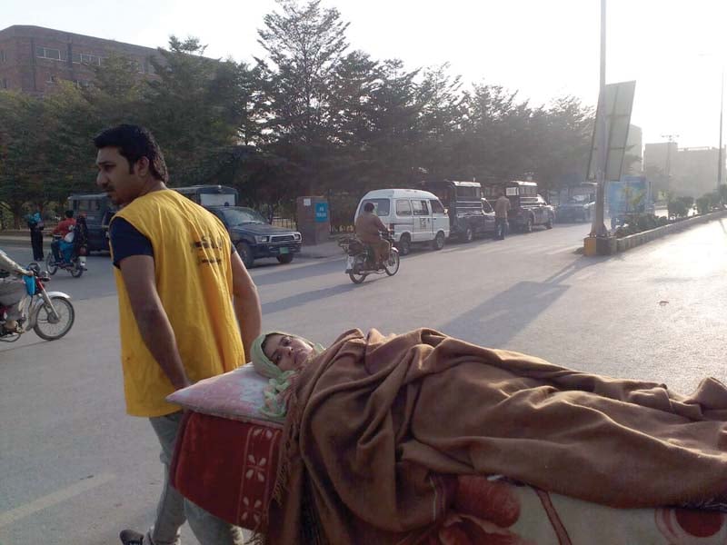 a paramedic takes a patient to an ambulance outside mayo hospital s emergency ward to shift her to another hospital photo express