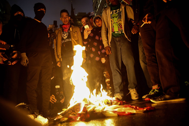 protesters burn an american flag on fifth avenue outside of trump tower november 9 2016 in new york city photo afp